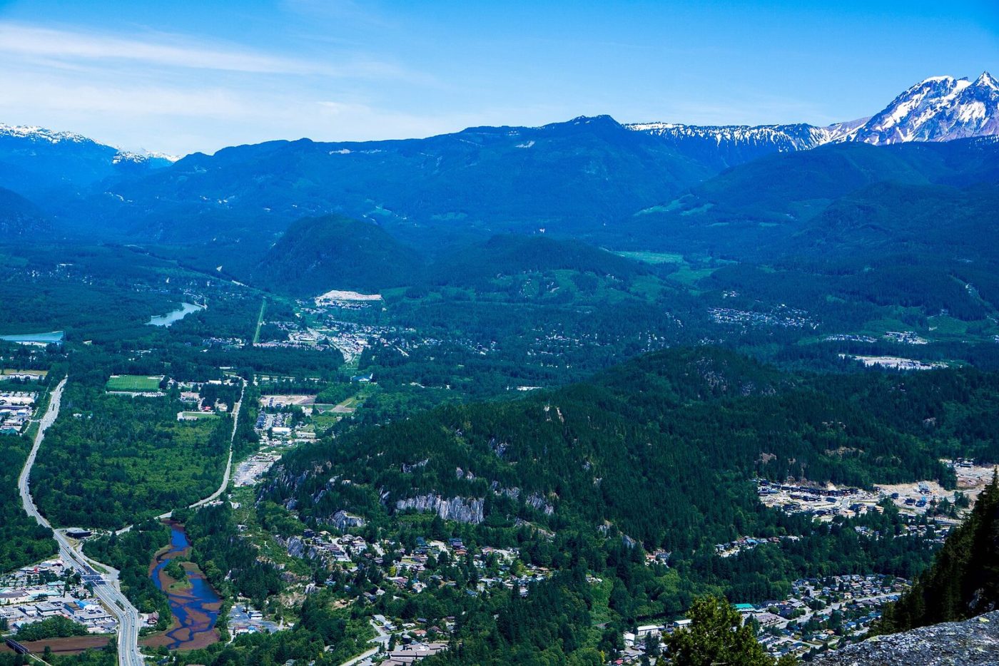 Downtown Squamish and the valley floor seen from the Stawamus Chief, with forested mountains behind