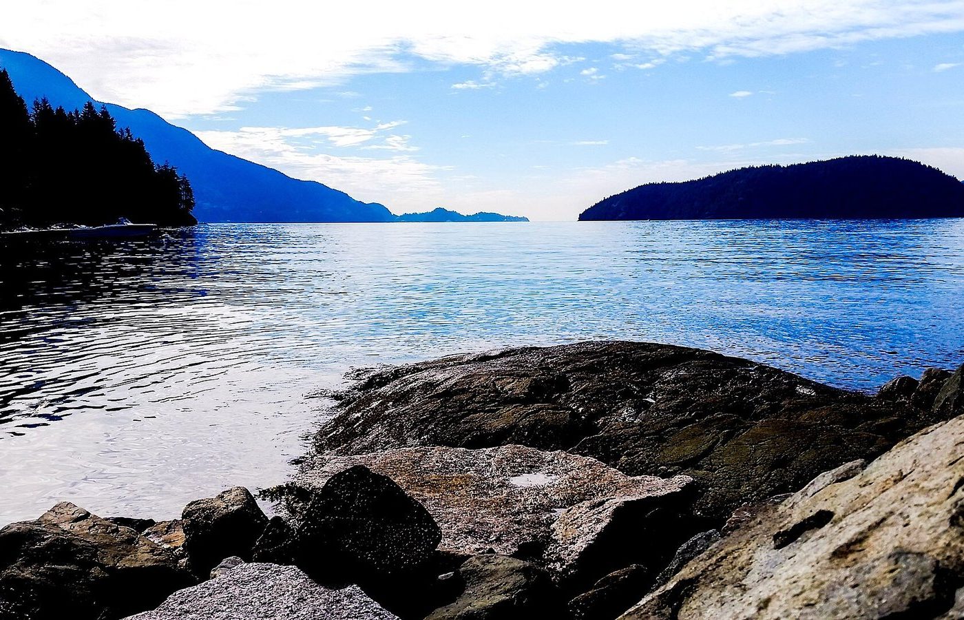 Rocky shoreline at Kelvin Grove Beach Park in Lions Bay, looking out over Howe Sound to forested islands