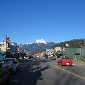 Cleveland Avenue, downtown Squamish's main street, with shops on both sides and a snow-capped peak beyond
