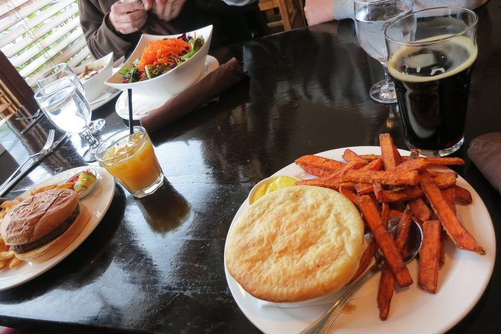 A pot pie with sweet potato fries and a dark beer on a table at Howe Sound Brewing in Squamish