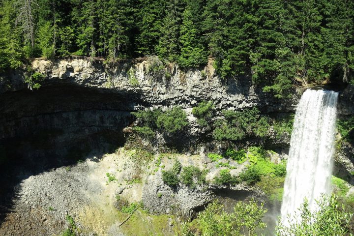 Brandywine Falls pouring over a dark basalt lip into the canyon, framed by forest and seen from the rim