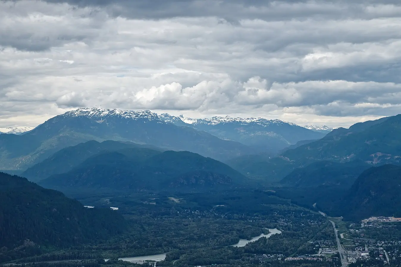 Elevated view over Squamish and the Sea to Sky valley from Stawamus Chief Provincial Park, with the Squamish River and snow-capped Coast Mountains in the background
