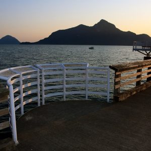Dusk over Howe Sound from the pier at Porteau Cove, with dark mountain silhouettes across the water