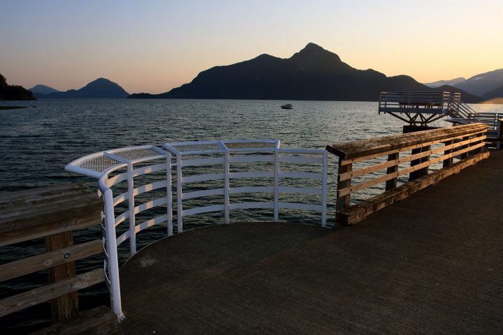 Dusk over Howe Sound from the pier at Porteau Cove, with dark mountain silhouettes across the water