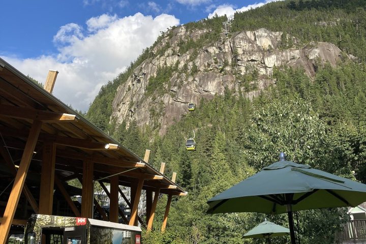 Sea to Sky Gondola base area with a cabin climbing toward the granite face of the Stawamus Chief